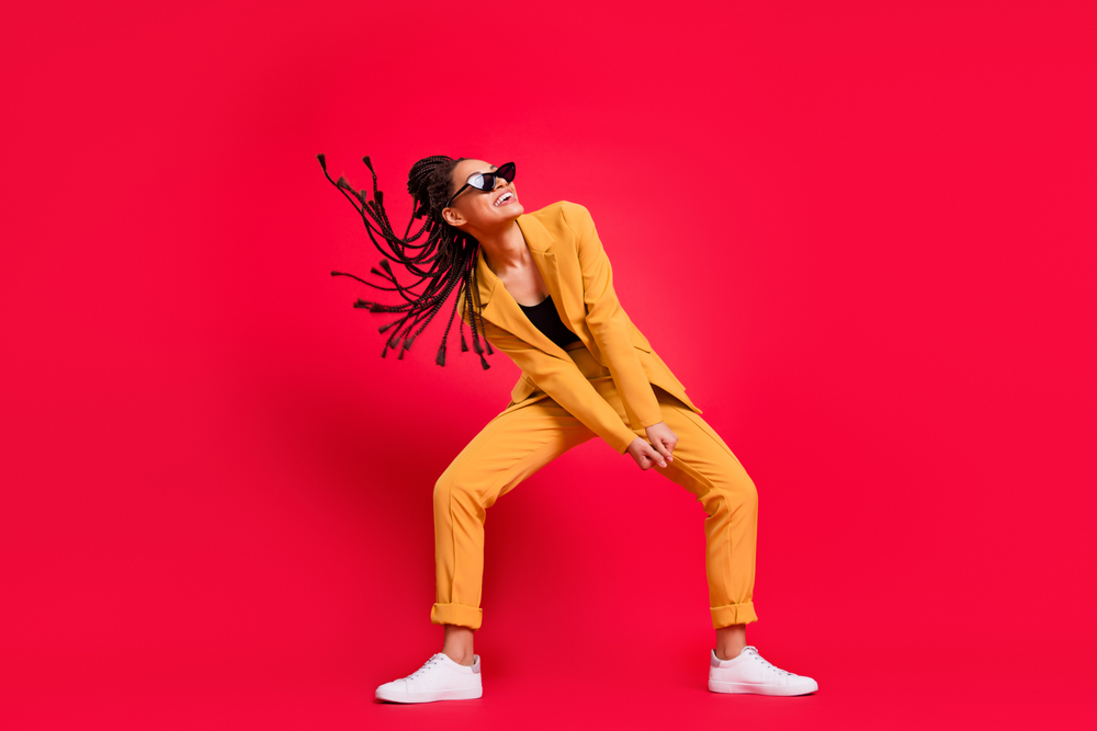 Young woman in yellow on a bright red background symbolising Change Vigour